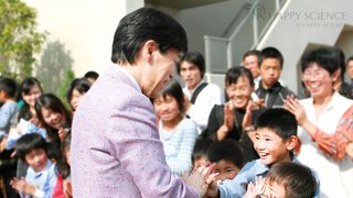 子どもたちに笑顔で声をかける大川総裁